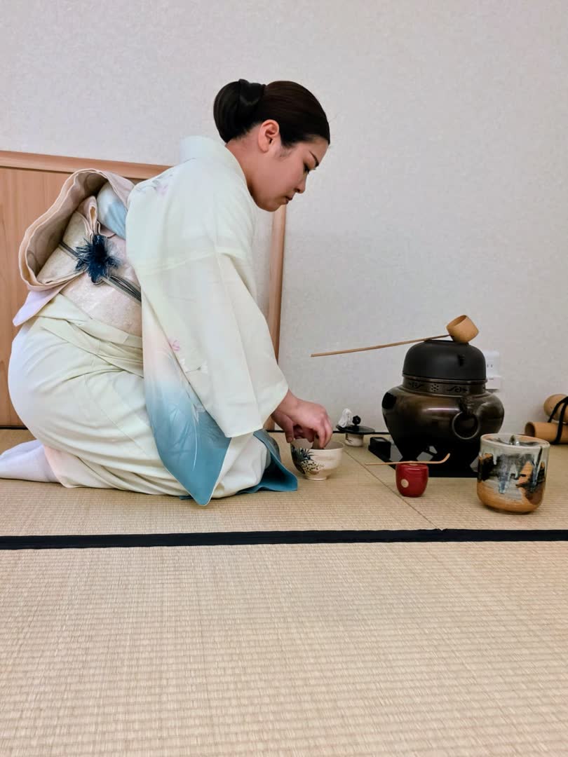 Mulher de quimono conduzindo a cerimônia japonesa do chá sobre tatame